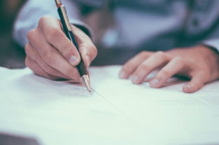 man writing on paper